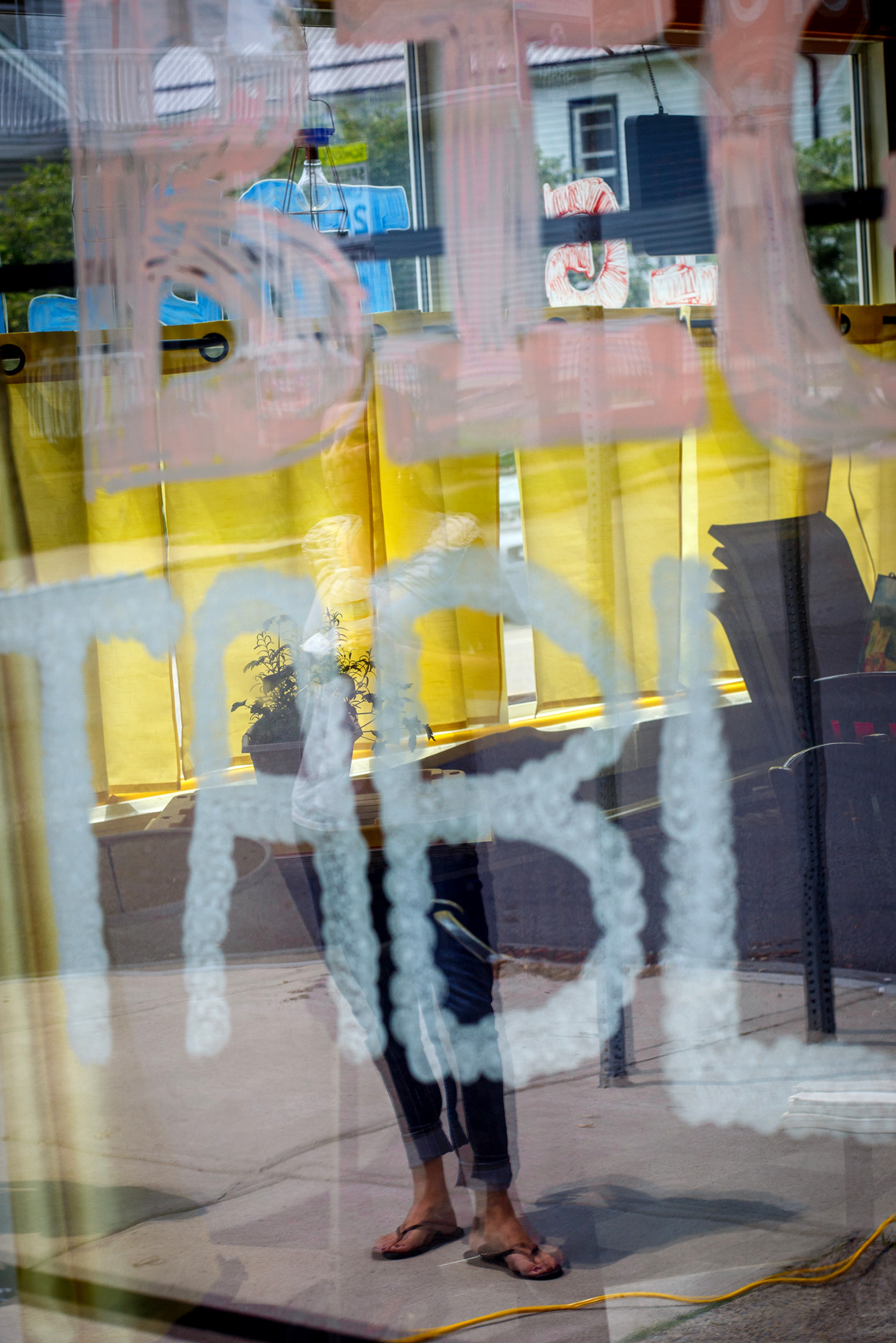 out of focus photo of a restaurant window with a woman standing outside the restaurant