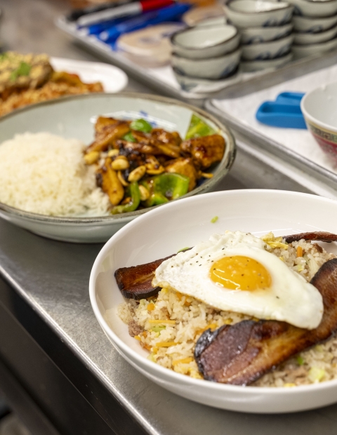 A table with bowls of food and a plate with an egg