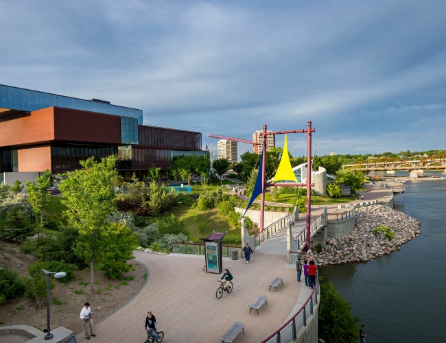 The boardwalk by the river with a large building in the background