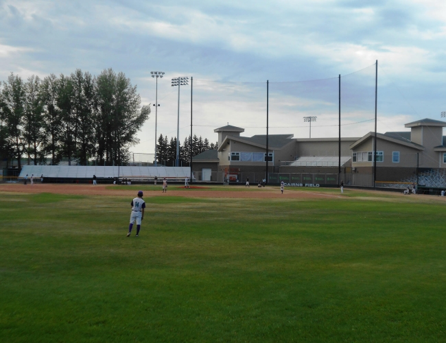 A player standing in the outfield at a baseball field