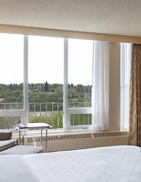 Hotel bedroom looking over greenery 