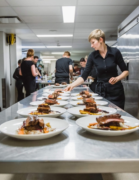 Prep kitchen with plates of food laid on counter