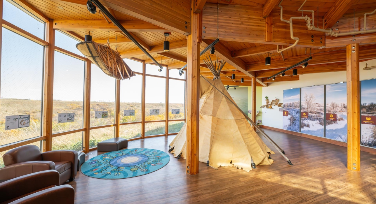 indoor area of Wanuskewin with teepee and hanging canoe