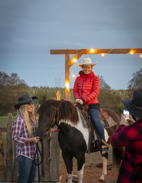 Woman sitting on a horse and another woman petting the horse