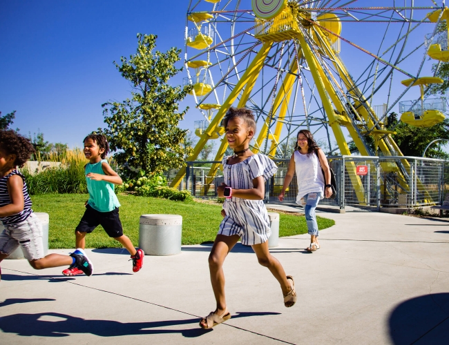 Children running and smiling at an amusement park