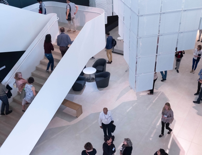 People walking in office lobby and large set of stairs